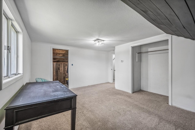 carpeted bedroom with a textured ceiling and a closet