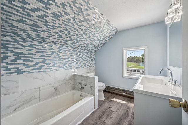 bathroom with toilet, wood finished floors, vanity, vaulted ceiling, and a bath