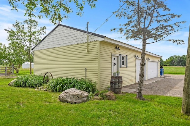 view of side of home featuring a garage and a yard