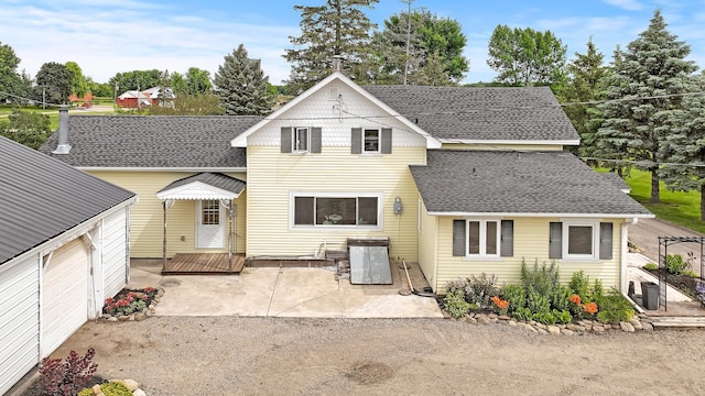 traditional-style house with a shingled roof and a patio area