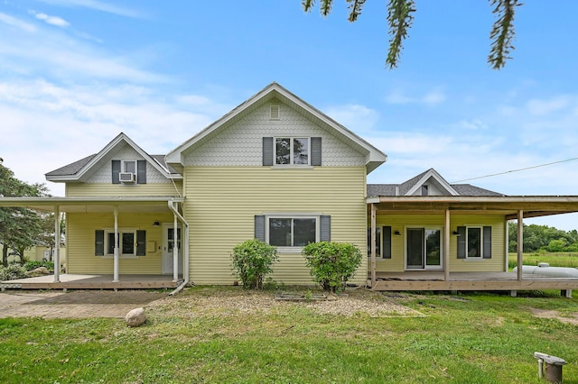 rear view of house with covered porch and a yard