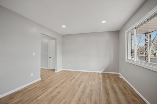 empty room featuring light wood-style floors, recessed lighting, and baseboards