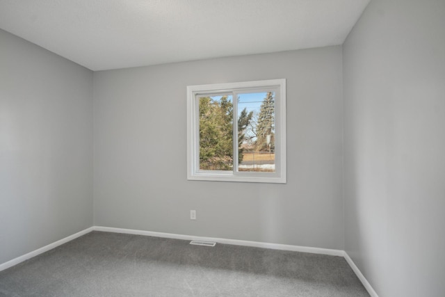 carpeted empty room featuring visible vents and baseboards