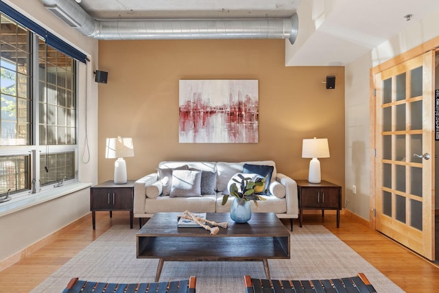 living room with visible vents, baseboards, and wood finished floors