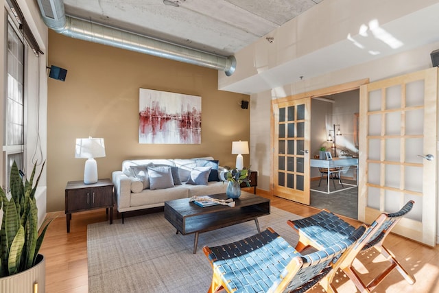 living room with baseboards, wood finished floors, and french doors