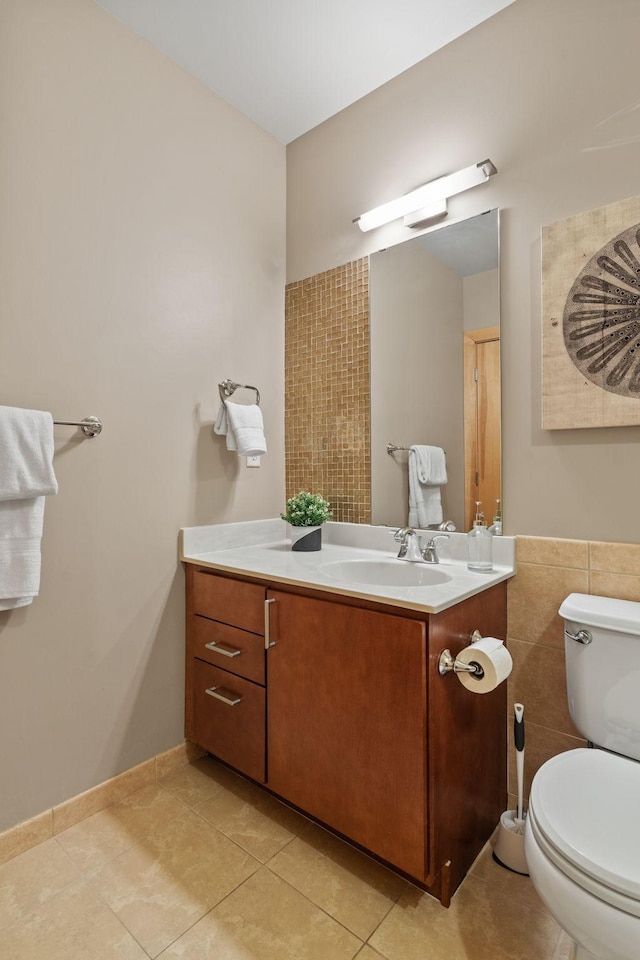 bathroom with toilet, tile patterned floors, tile walls, and vanity