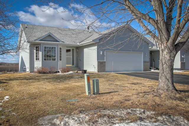 ranch-style home featuring a garage, brick siding, driveway, roof with shingles, and a front yard