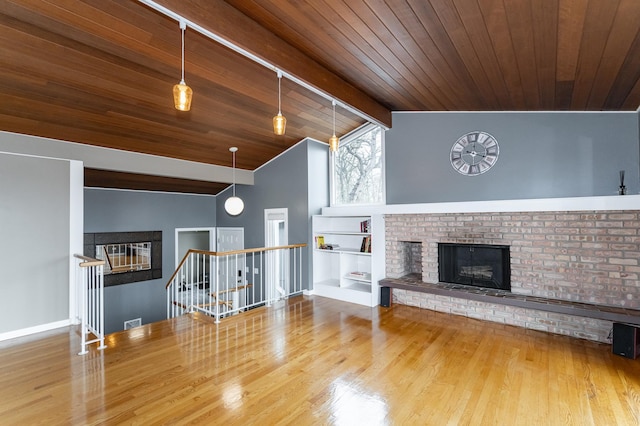 1509 Woodland Dr SW, Rochester, MN 55902 - unfurnished living room with lofted ceiling with beams, a fireplace, baseboards, wooden ceiling, and wood finished floors