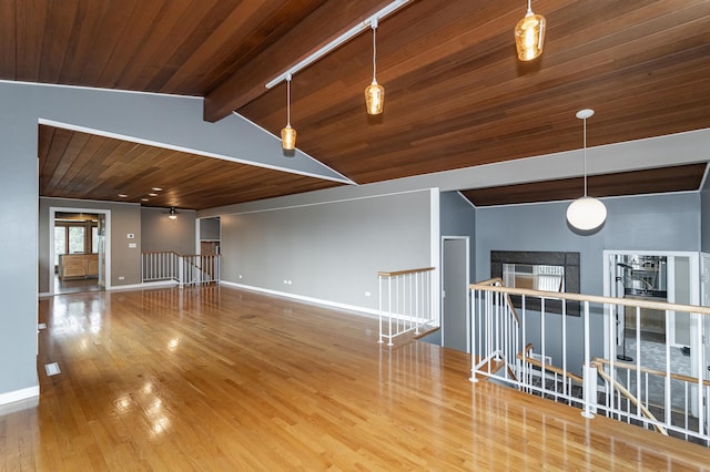1509 Woodland Dr SW, Rochester, MN 55902 - unfurnished room featuring lofted ceiling with beams, a fireplace, baseboards, wooden ceiling, and wood finished floors