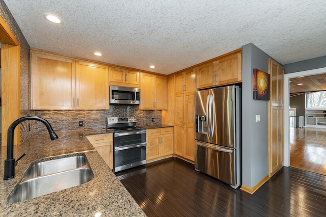 1509 Woodland Dr SW, Rochester, MN 55902 - kitchen with appliances with stainless steel finishes, a sink, a textured ceiling, dark wood finished floors, and tasteful backsplash