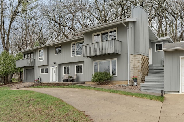 1509 Woodland Dr SW, Rochester, MN 55902 - view of front of home with a garage, a balcony, a chimney, and concrete driveway