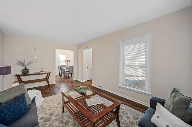 living room with dark wood-type flooring and baseboards