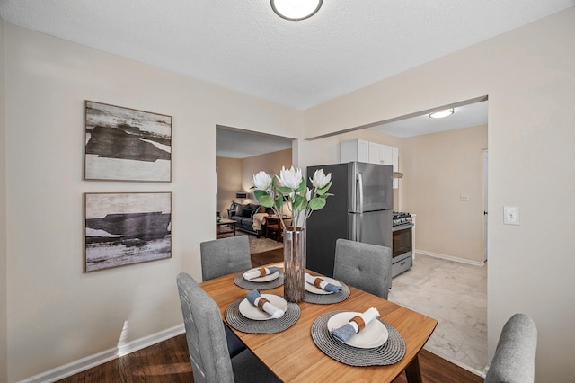 dining area with a textured ceiling and baseboards