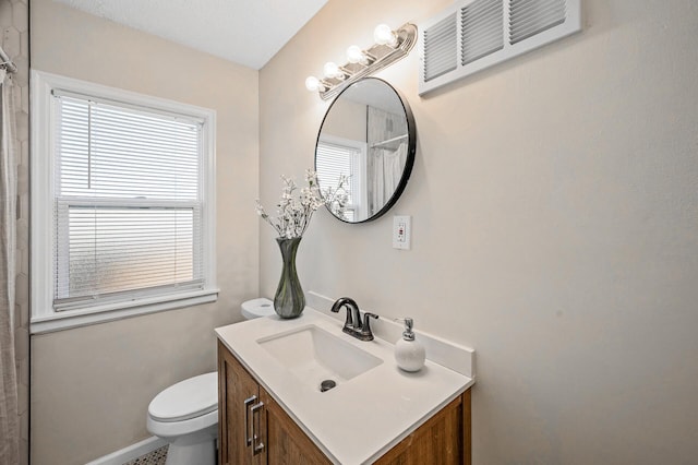 bathroom with curtained shower, visible vents, vanity, and toilet