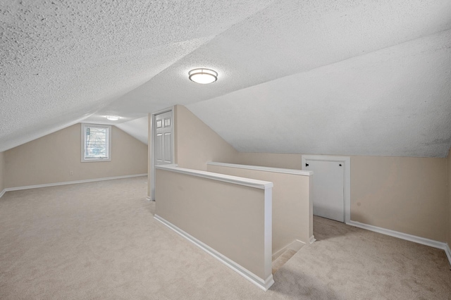 bonus room with light carpet, a textured ceiling, lofted ceiling, and baseboards