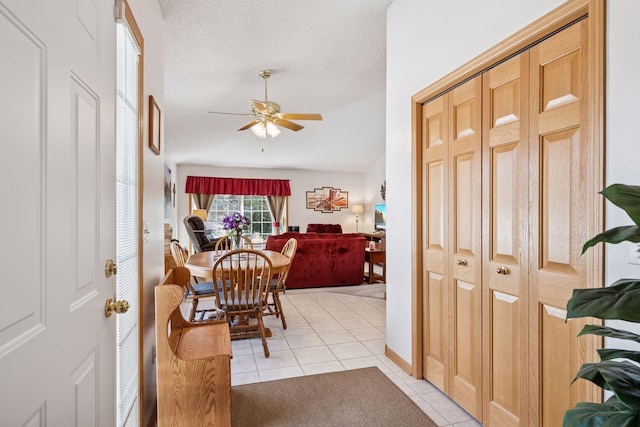 dining room featuring light tile patterned floors, ceiling fan, and a textured ceiling