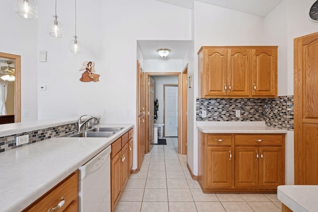 kitchen featuring white dishwasher, light tile patterned flooring, a sink, light countertops, and pendant lighting