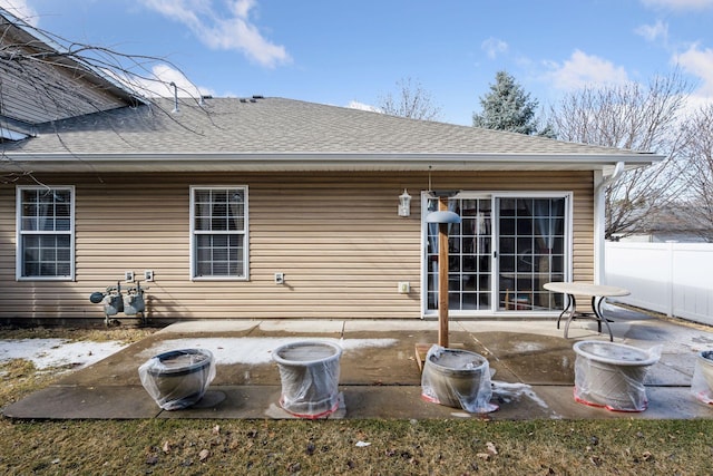 back of house with a patio area, a shingled roof, and fence