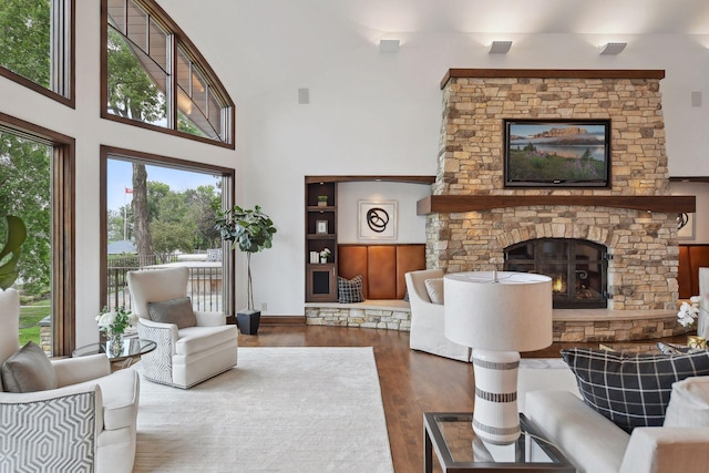 living room featuring a fireplace, a high ceiling, and wood finished floors