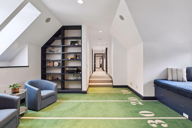 interior space featuring lofted ceiling, carpet floors, built in shelves, and baseboards