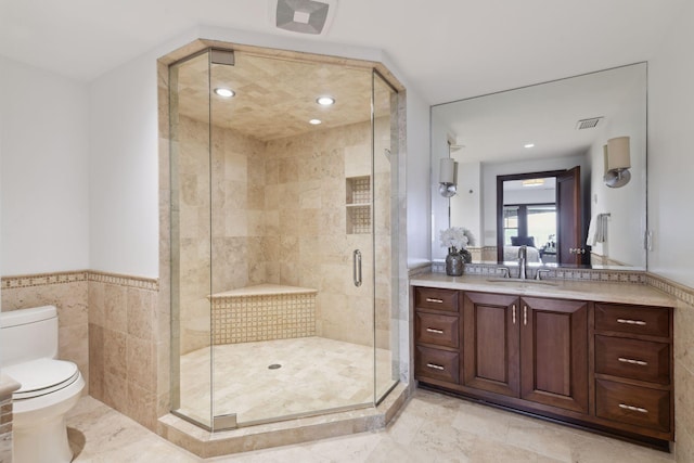 full bath featuring a stall shower, visible vents, toilet, vanity, and tile walls