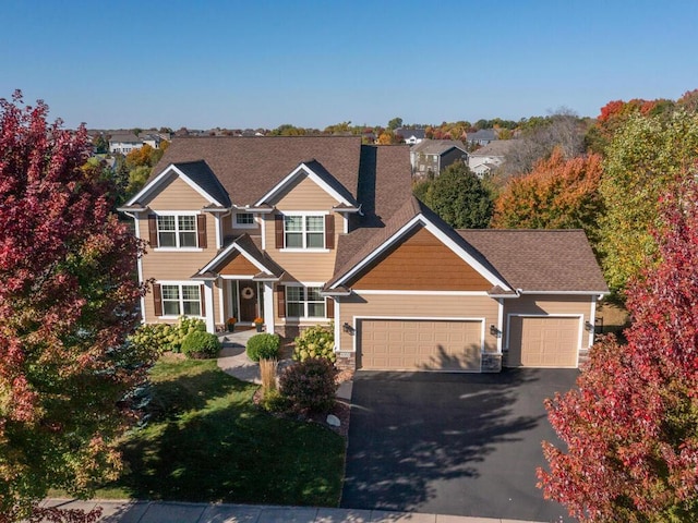 craftsman inspired home with a garage and driveway