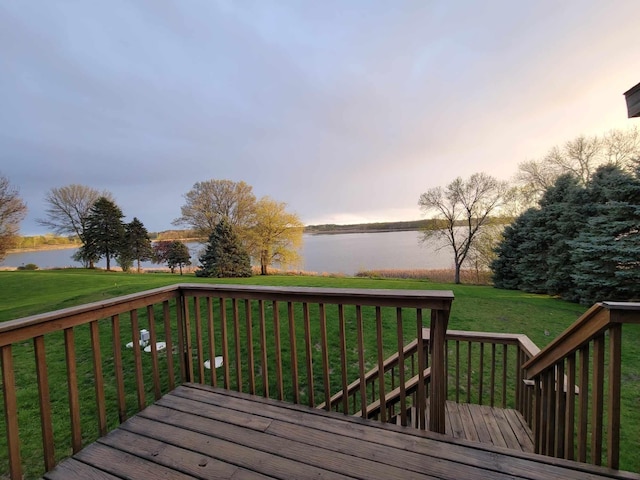 deck with a lawn and a water view