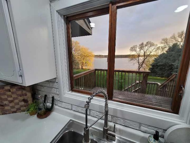 interior space featuring a water view and white cabinetry