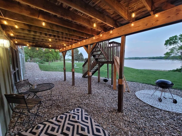 view of patio / terrace featuring stairs and a water view