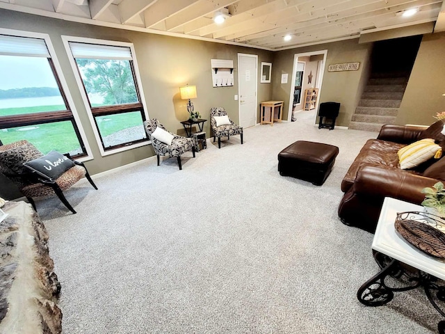 living area featuring carpet, a water view, baseboards, and stairs