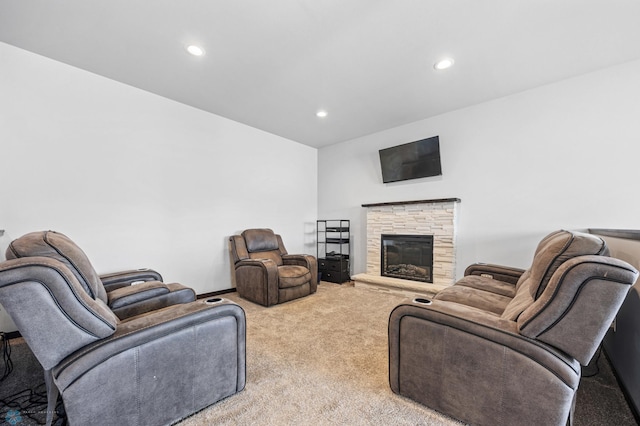 living area with carpet, a stone fireplace, and recessed lighting