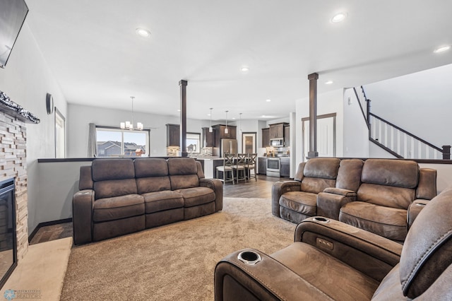 living area with stairs, recessed lighting, a fireplace, and an inviting chandelier