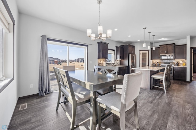 dining space with recessed lighting, dark wood-type flooring, visible vents, baseboards, and an inviting chandelier