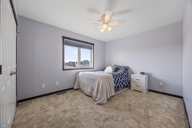 carpeted bedroom featuring a ceiling fan, visible vents, and baseboards