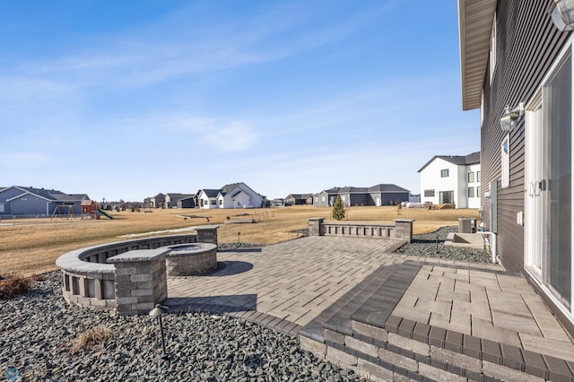 view of patio / terrace with a residential view, a fire pit, and a playground