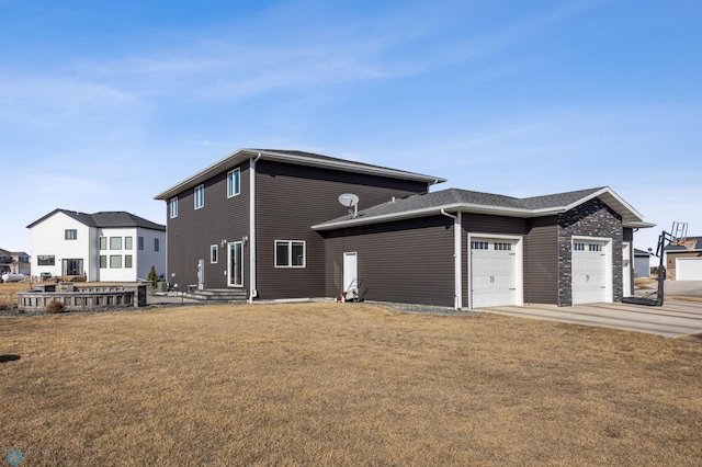 view of front of home featuring concrete driveway, a front lawn, and an attached garage