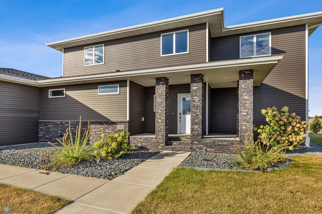 530 Piper St, Kindred, ND 58051 - view of front of home with a porch, a front lawn, and stone siding
