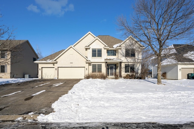 traditional-style home with an attached garage, driveway, and stucco siding