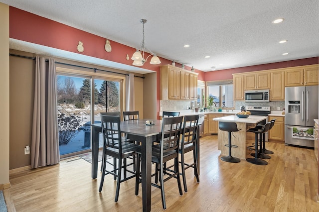 dining space featuring a textured ceiling, recessed lighting, and light wood-style floors