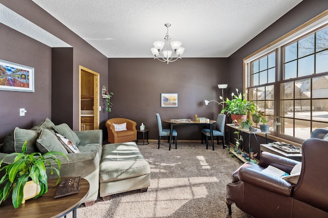 living room featuring carpet floors, a textured ceiling, baseboards, and an inviting chandelier