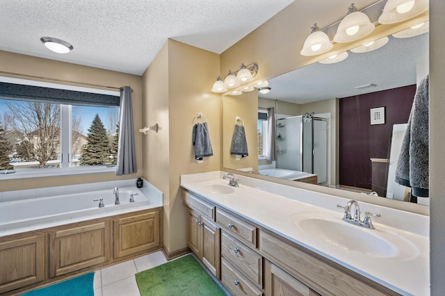 bathroom with a garden tub, a stall shower, tile patterned flooring, and a sink