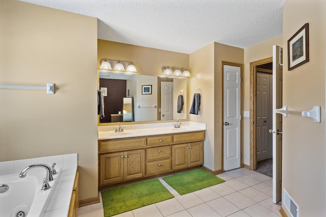 bathroom featuring double vanity, tile patterned floors, a jetted tub, a textured ceiling, and a closet