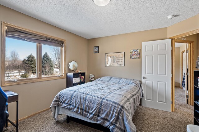 carpeted bedroom featuring baseboards and a textured ceiling