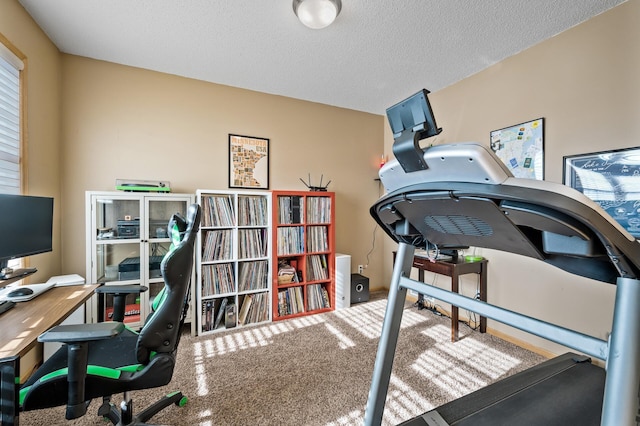 carpeted home office featuring a textured ceiling