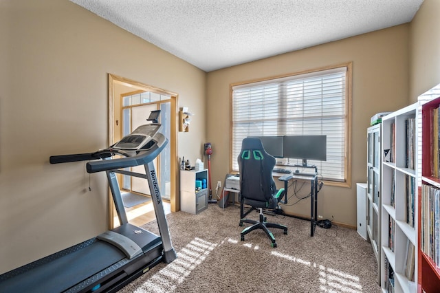 carpeted office featuring baseboards and a textured ceiling