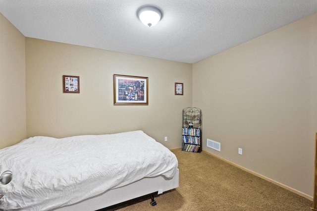 carpeted bedroom featuring visible vents, a textured ceiling, and baseboards