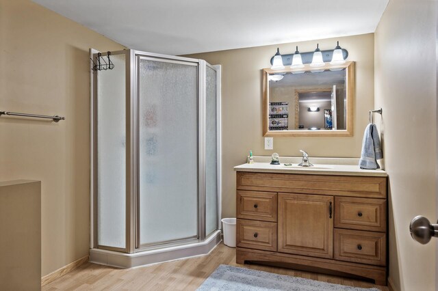 bathroom featuring a stall shower, wood finished floors, and vanity