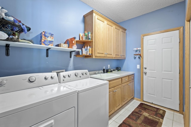 laundry room featuring cabinet space, light tile patterned floors, independent washer and dryer, a textured ceiling, and a sink