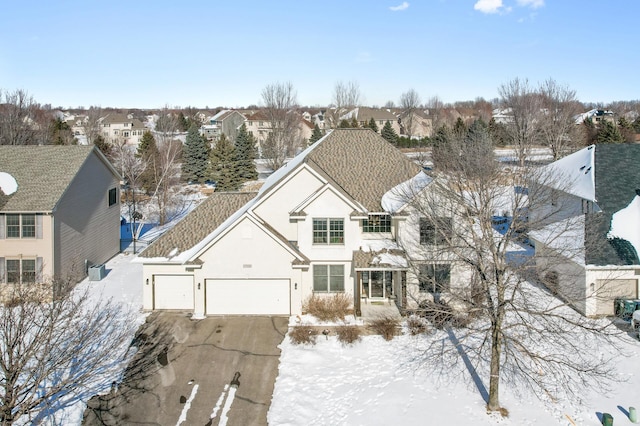 view of front of home featuring a residential view, roof with shingles, driveway, and stucco siding