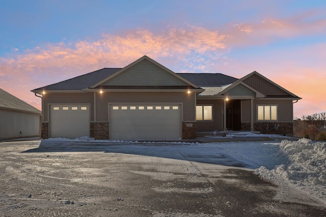 craftsman house featuring a garage and stone siding